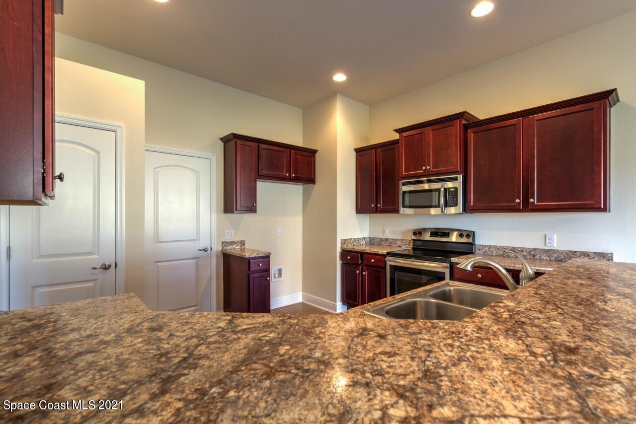 784 Moment Circle Cocoa, FL 32926 - Photo 6 of 14 a kitchen with stainless steel appliances granite countertop a refrigerator stove and sink