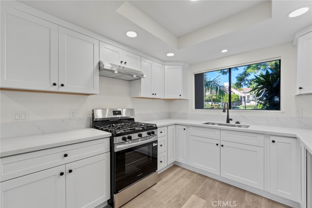 711 West 1st Street Santa Ana, CA 92701 - Photo 1 of 23 a kitchen with stainless steel appliances granite countertop white cabinets and a stove top oven