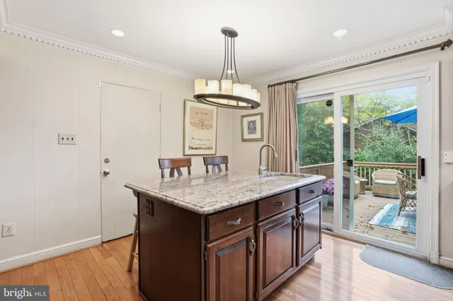 a kitchen with a stove a sink and a wooden floor