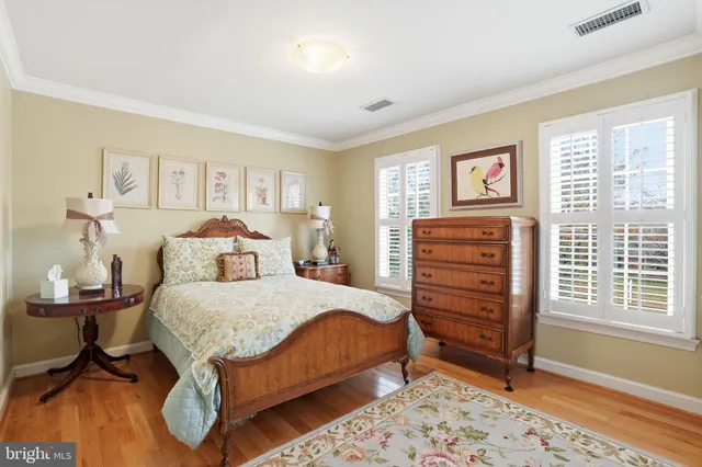 a bedroom with a bed and a dresser next to a window