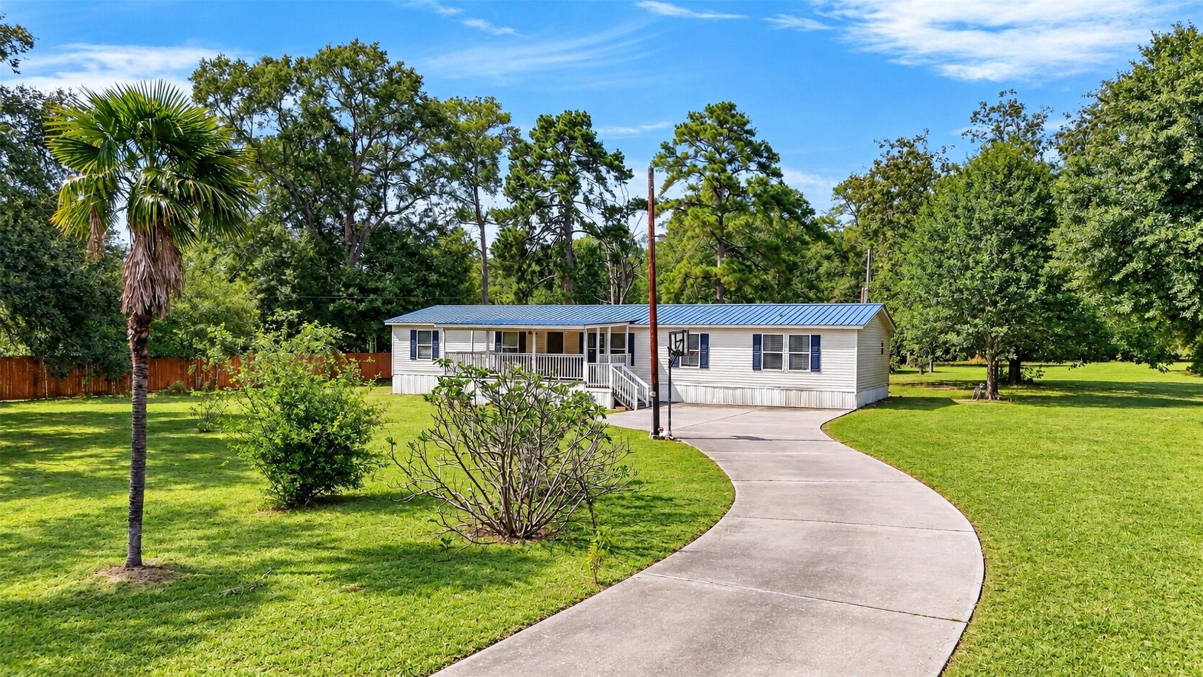 2581 Mann Road Conroe, TX 77303 - Photo 6 of 32 Front view showcasing the long driveway, mature trees, and generous outdoor space.