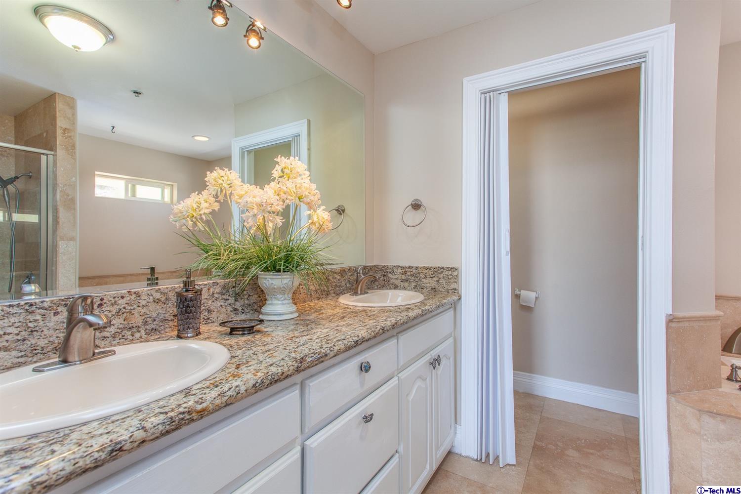 40251 Flintrock Road Leona Valley, CA 93551 - Photo 19 of 32 a bathroom with a granite countertop sink and a mirror