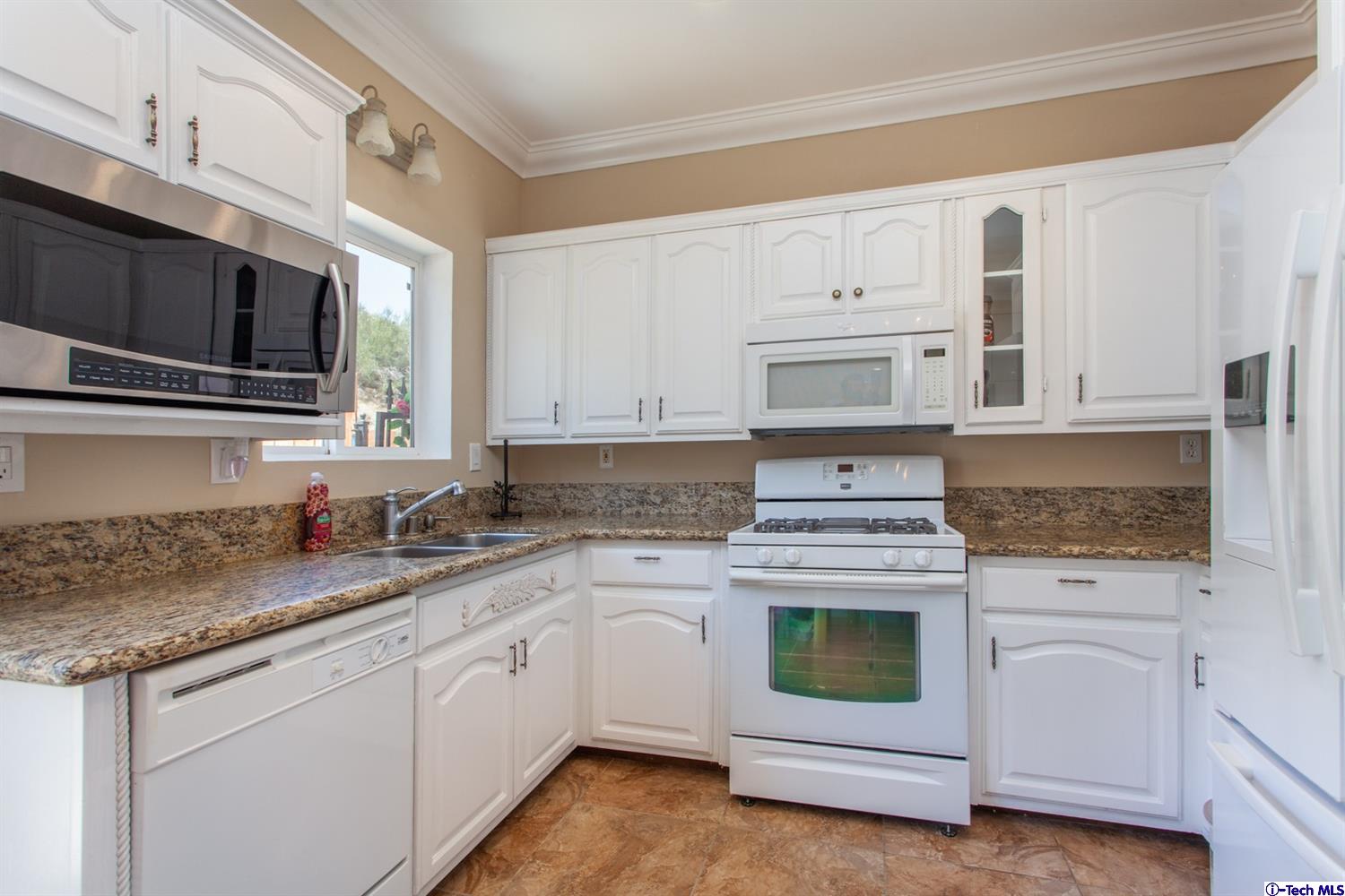 40251 Flintrock Road Leona Valley, CA 93551 - Photo 10 of 32 a kitchen with granite countertop white cabinets stainless steel appliances and sink