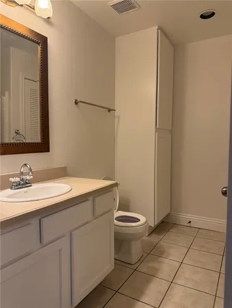 a bathroom with a sink a toilet a mirror and vanity