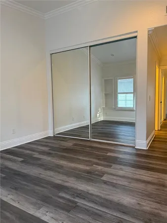 a view of empty room with window and wooden floor