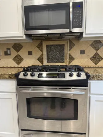 a stove top oven sitting inside of a kitchen