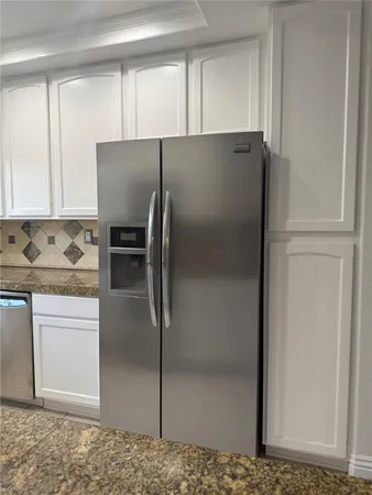a metallic refrigerator freezer sitting in a kitchen