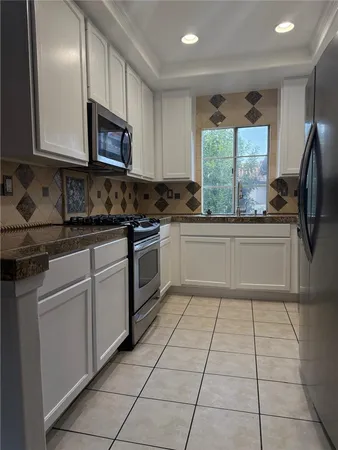 a kitchen with stainless steel appliances granite countertop a sink and a stove