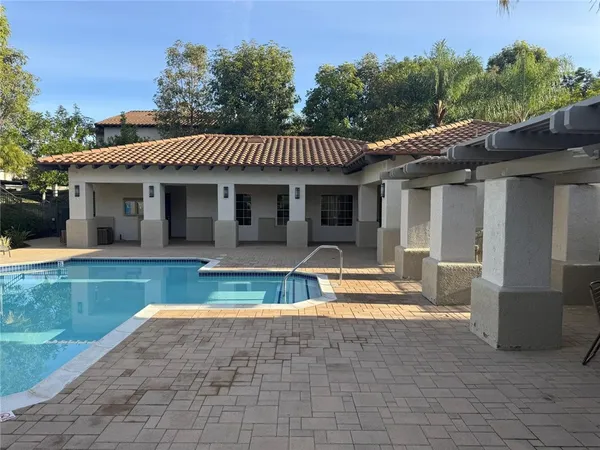 a view of a house with pool and a yard