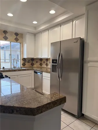 a kitchen with stainless steel appliances granite countertop a refrigerator a sink and a stove