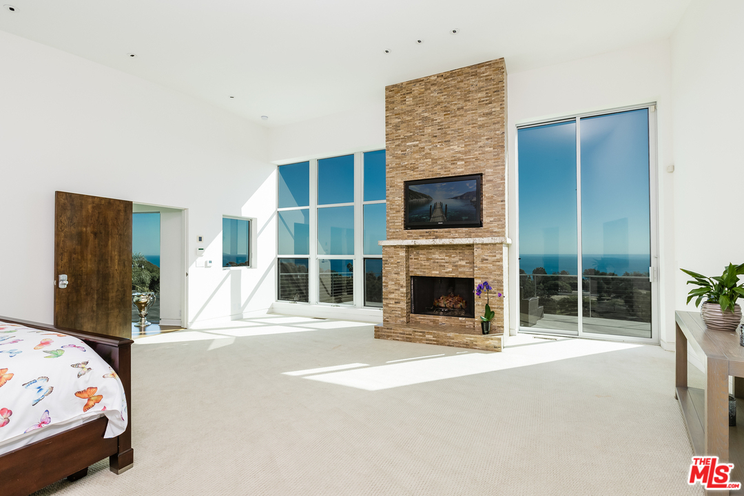 27366 Winding Way Malibu, CA 90265 - Photo 18 of 43 a bedroom with a bed and a fireplace