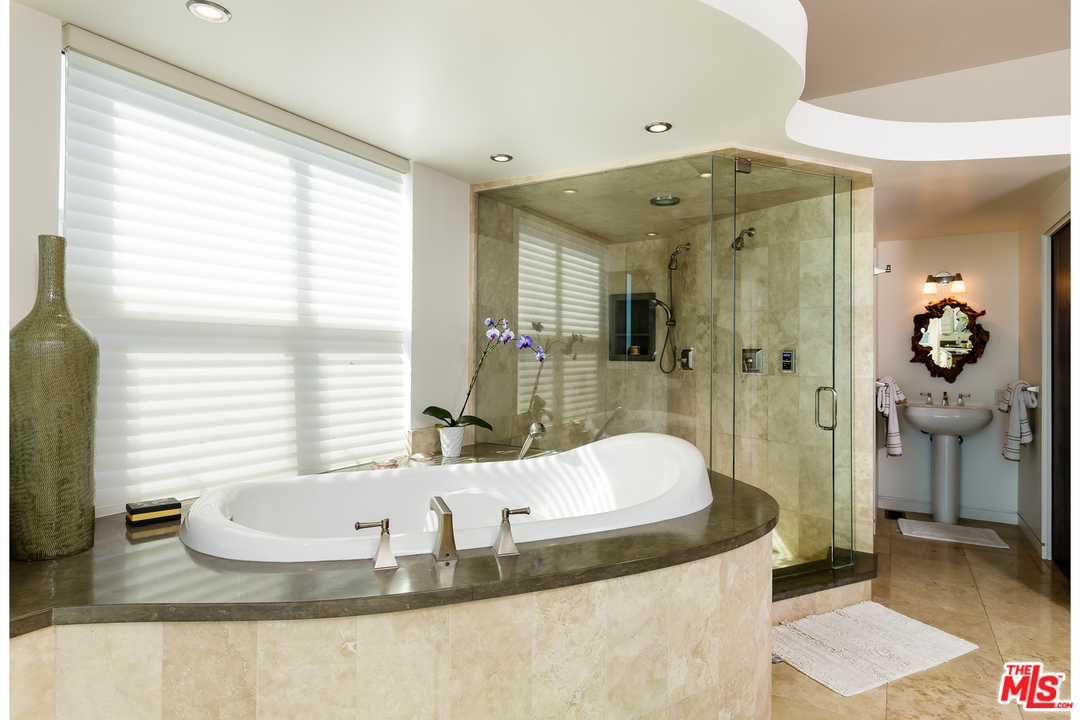 27366 Winding Way Malibu, CA 90265 - Photo 20 of 43 a bathroom with a granite countertop sink a bathtub and shower
