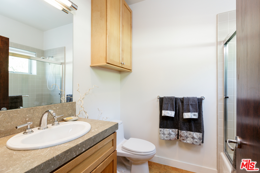 27366 Winding Way Malibu, CA 90265 - Photo 30 of 43 a bathroom with a granite countertop sink a toilet and a mirror