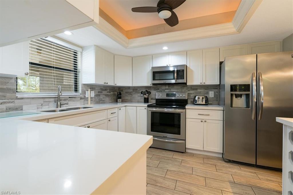 75 St Andrews Boulevard, Unit C301 Naples, FL 34113 - Photo 2 of 41 a kitchen with stainless steel appliances granite countertop a sink a stove top oven a refrigerator with island and cabinets