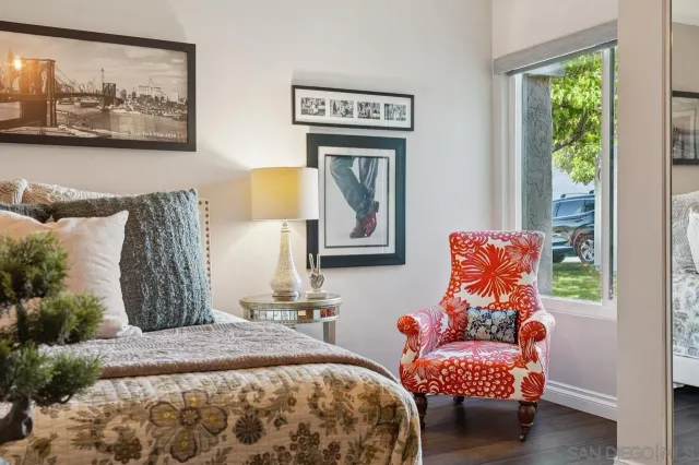 a bedroom with bed and a painting on the wall