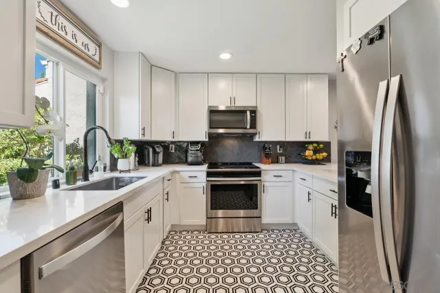a kitchen with a sink stainless steel appliances and white cabinets