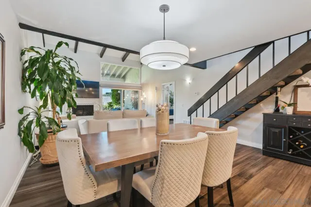 a view of a dining room with furniture a potted plant and wooden floor