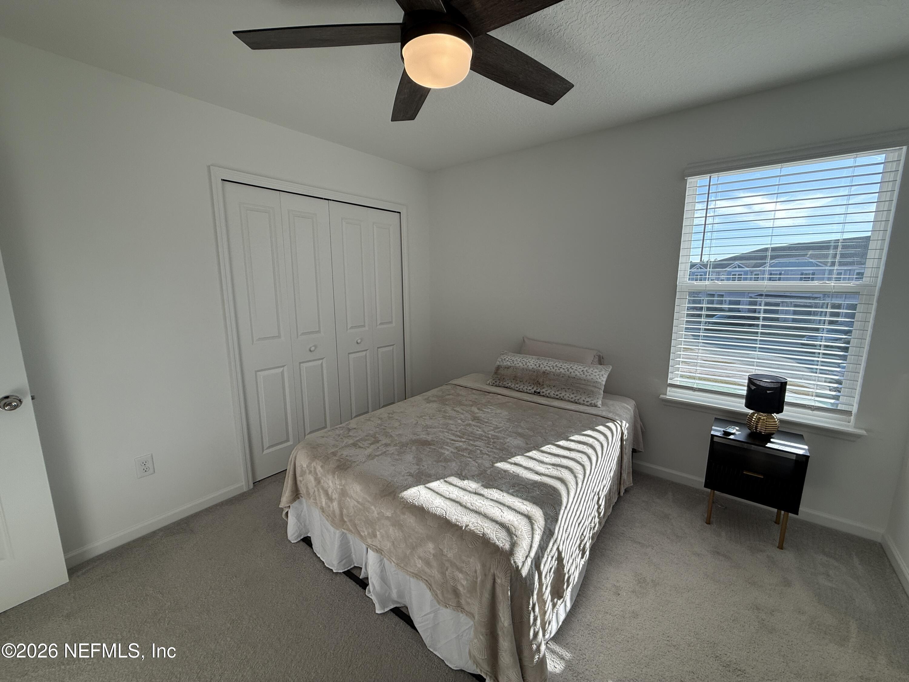 72 Bramble Court St. Augustine, FL 32092 - Photo 27 of 35 a bedroom with a bed and a chandelier