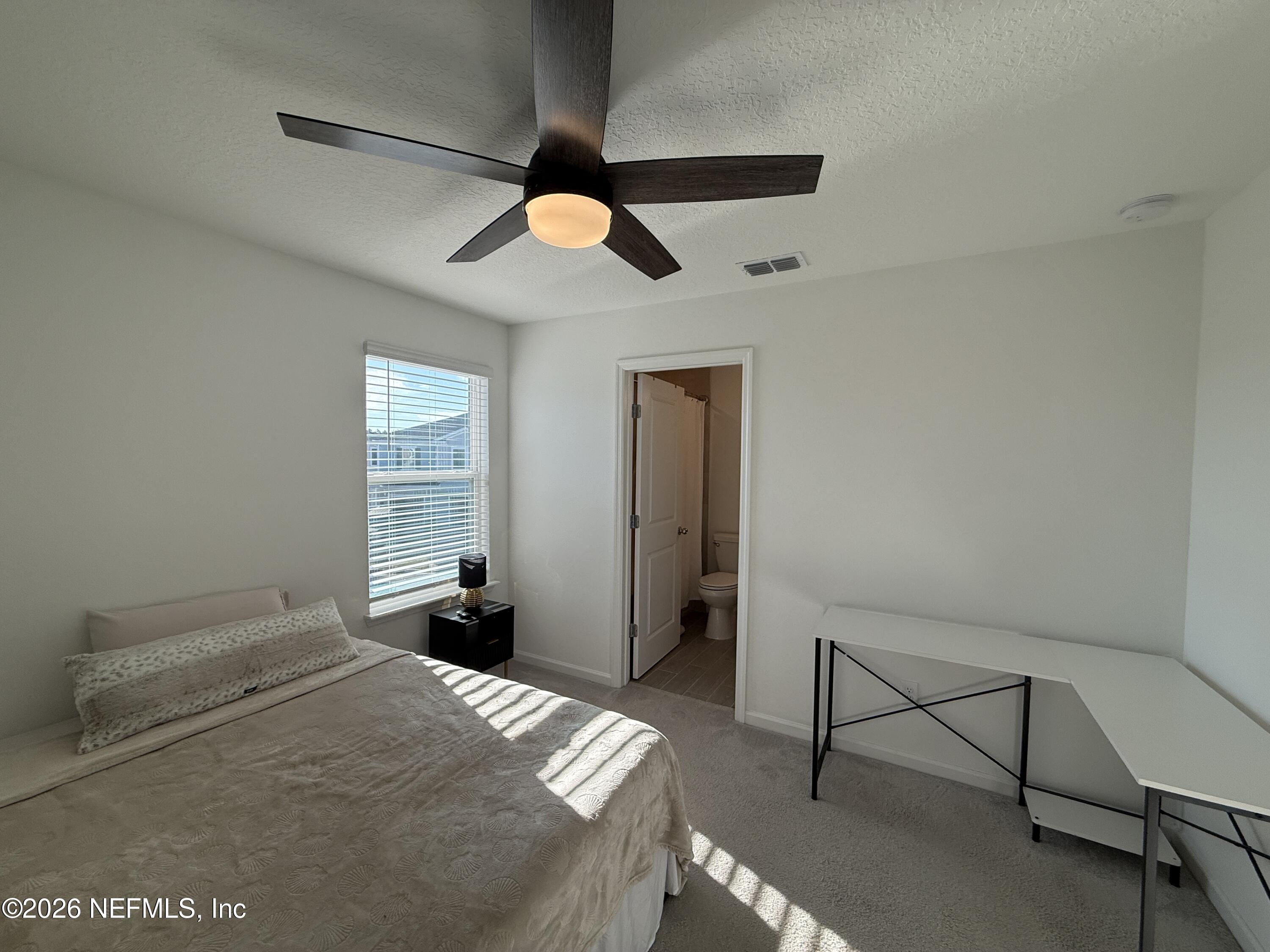 72 Bramble Court St. Augustine, FL 32092 - Photo 28 of 35 a bedroom with a bed and a chandelier