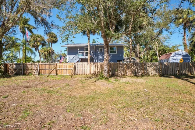a view of a backyard with table and chairs and a tree