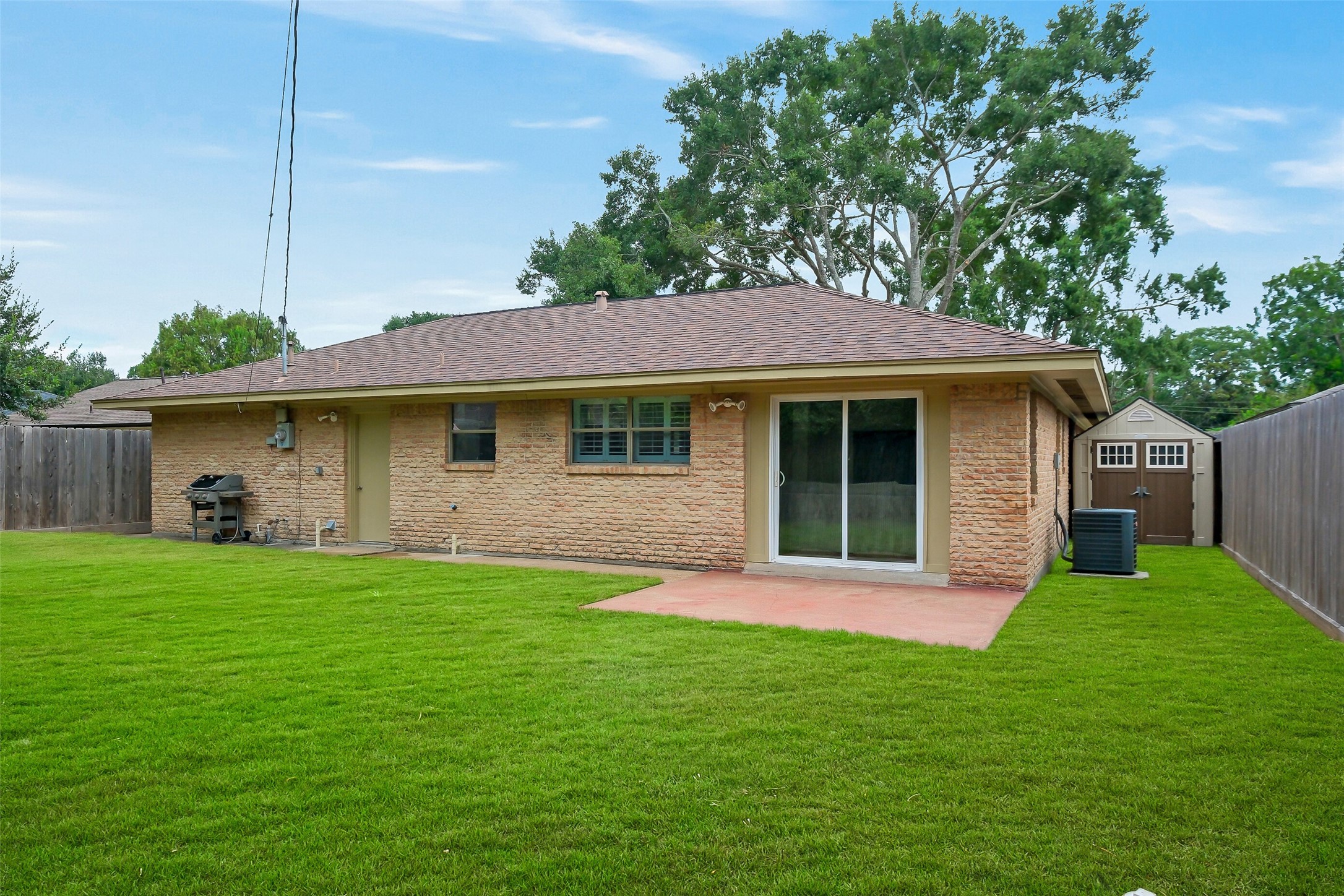 4415 Spellman Road Houston, TX 77035 - Photo 18 of 19 A second view highlights the backyard’s added storage shed, offering a convenient place to keep lawn equipment, gardening supplies, outdoor tools, bikes, or seasonal items tucked away and organized. The surrounding yard still leaves plenty of usable green space.