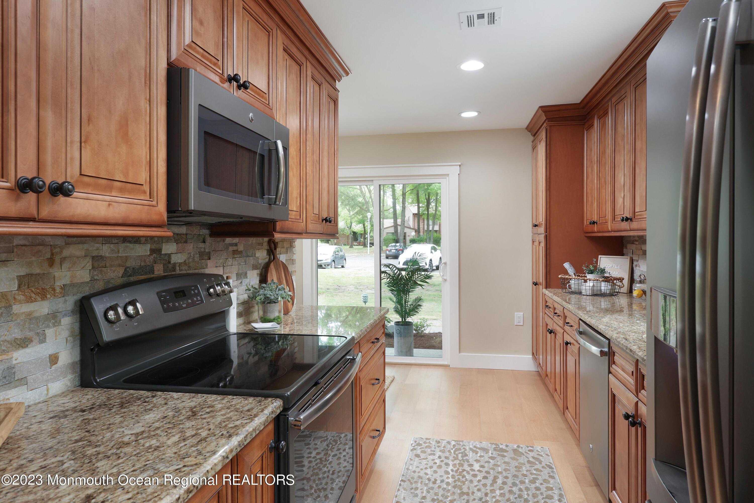 29 Manchester Court Red Bank, NJ 07701 - Photo 12 of 49 a kitchen with stainless steel appliances granite countertop a stove a sink and a microwave