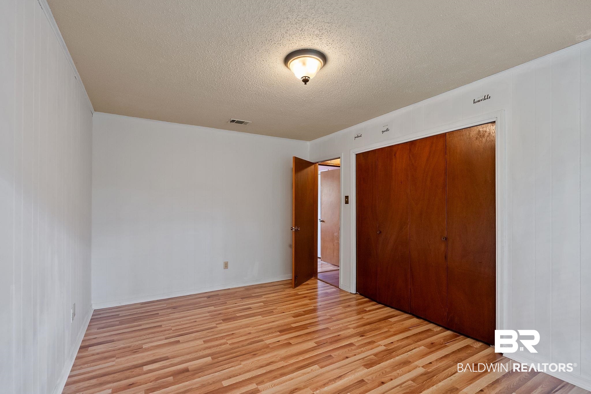 716 North Cedar Street Foley, AL 36535 - Photo 15 of 25 Room featuring wood-finish flooring and white paneled walls