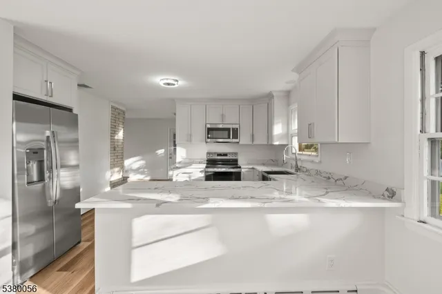 a kitchen with stainless steel appliances granite countertop a sink refrigerator and cabinets