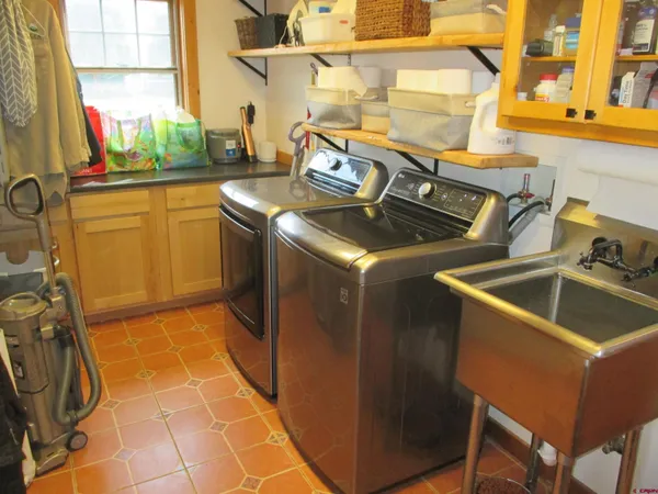 a kitchen that has a sink stove top oven and cabinets