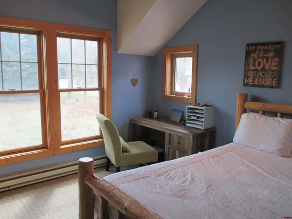 a bedroom with two beds and a large window