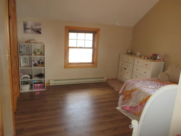 a room with a bed and a wooden floor