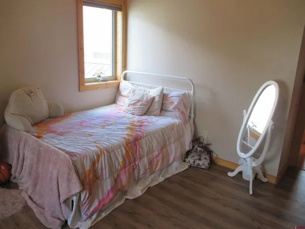 a bedroom with a bed a mirror and a window