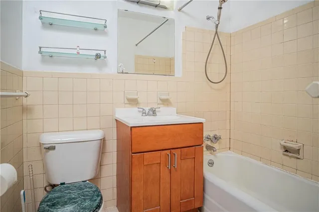 a bathroom with a granite countertop sink a toilet and shower