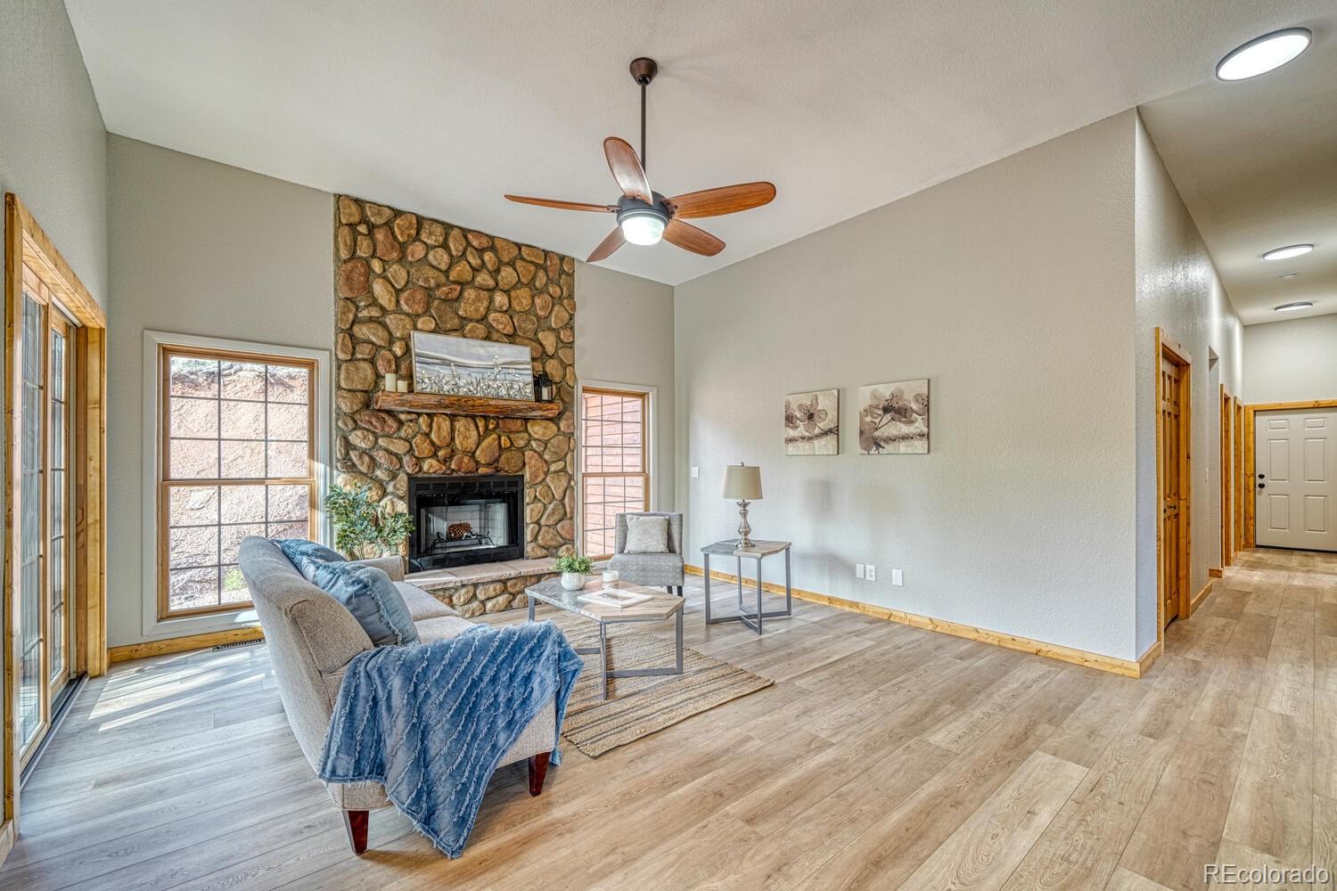 318 Southgate Road Florissant, CO 80816 - Photo 12 of 48 a living room with furniture a fireplace and wooden floor