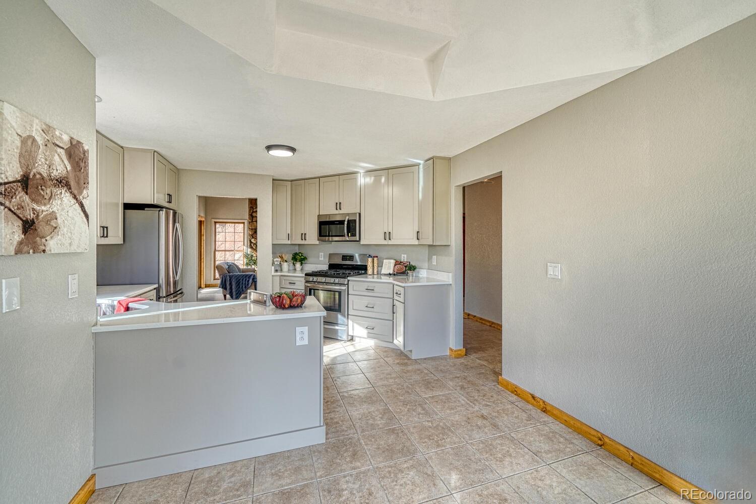 318 Southgate Road Florissant, CO 80816 - Photo 10 of 48 a kitchen with white cabinets and stainless steel appliances