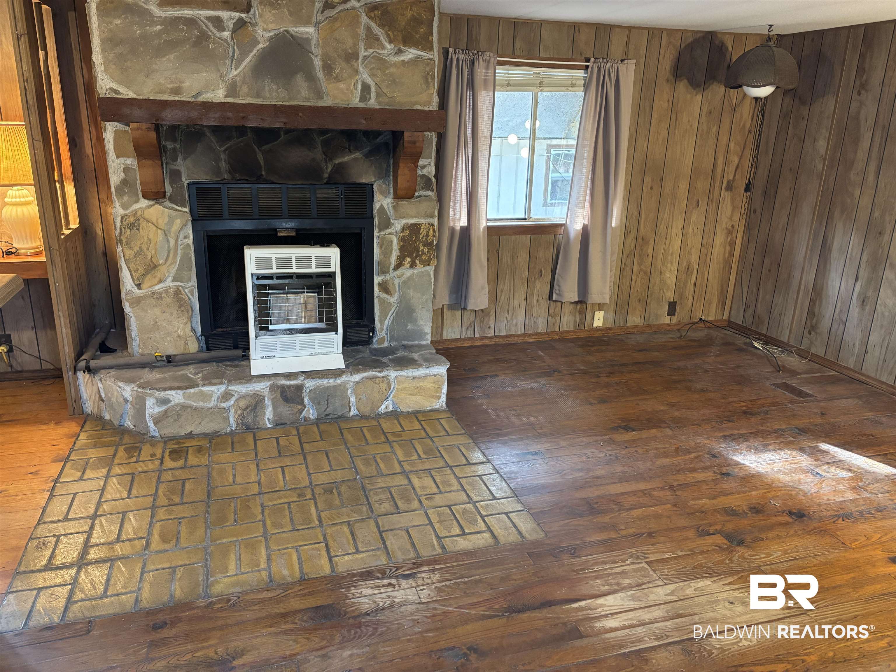 15575 Rogers Drive Chunchula, AL 36521 - Photo 31 of 42 Unfurnished living room featuring wood walls, a fireplace, dark wood finished floors, and heating unit