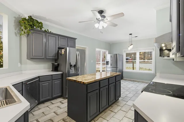 a kitchen with stainless steel appliances granite countertop a refrigerator a stove and a sink