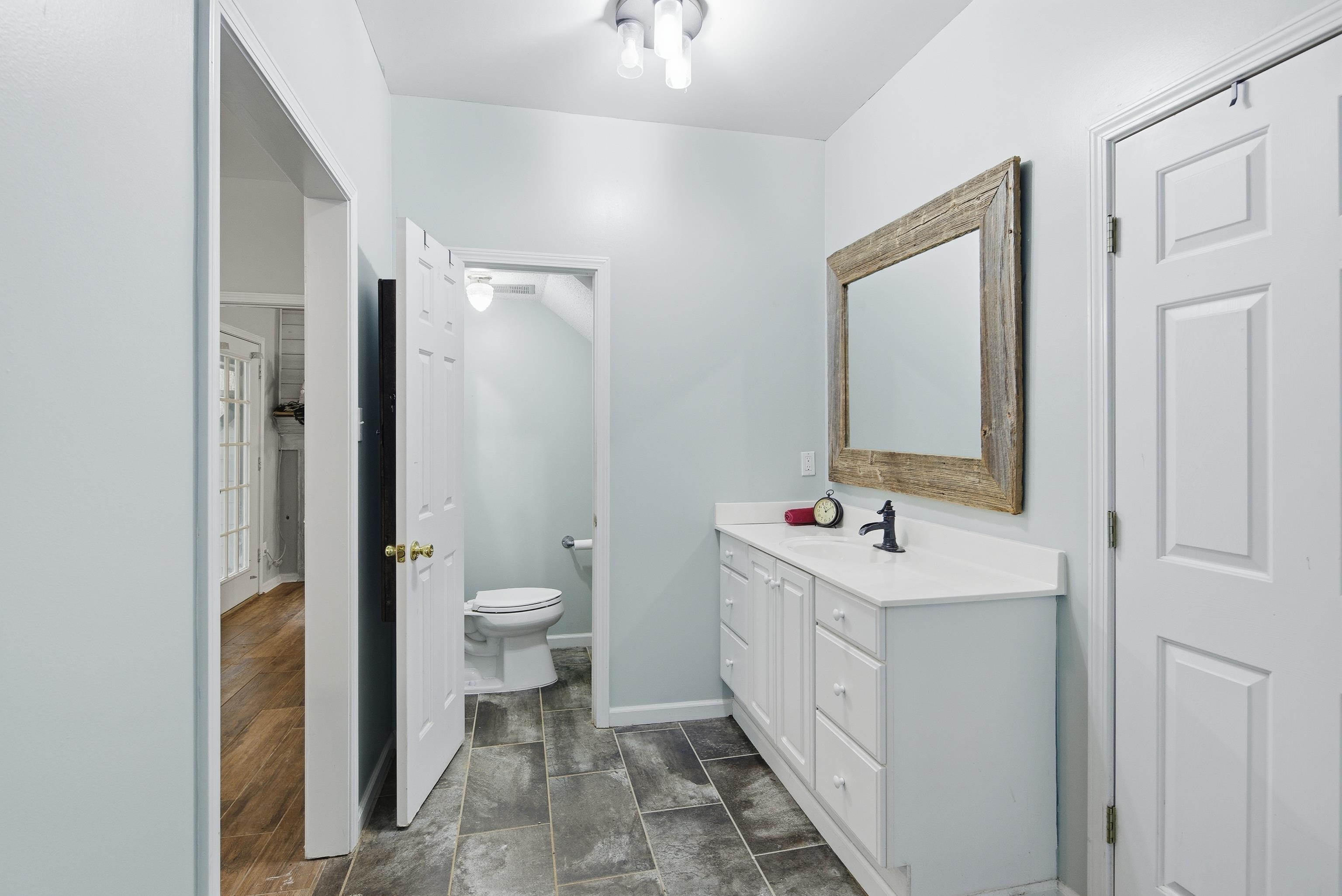 1755 Country Club Road Somerville, TN 38068 - Photo 29 of 40 a bathroom with a double vanity sink toilet and mirror