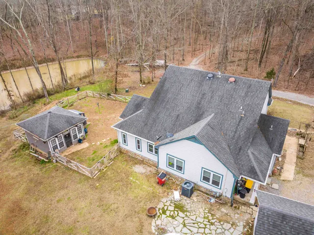 an aerial view of residential houses with outdoor space and trees
