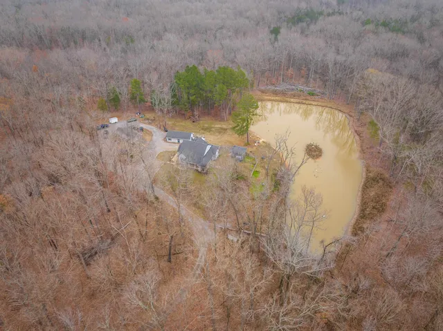an aerial view of a house with a yard and lake view