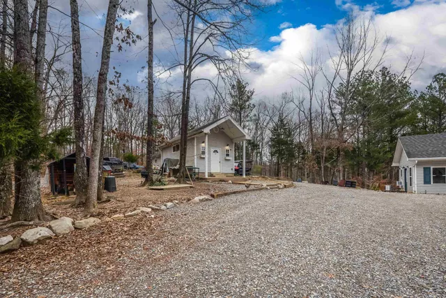 a view of a house with a big yard and large trees