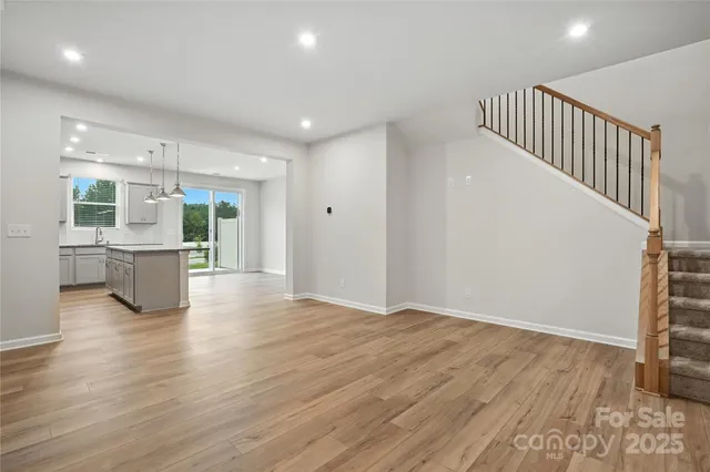 a view of a kitchen with a fridge and wooden floor