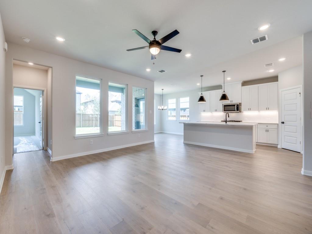 14565 Helena Street Pilot Point, TX 76258 - Photo 5 of 17 The open concept main floor features beautiful flooring, walls of windows, a dream kitchen and so much more!