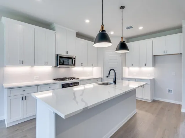 a kitchen with stainless steel appliances granite countertop a sink stove and cabinets