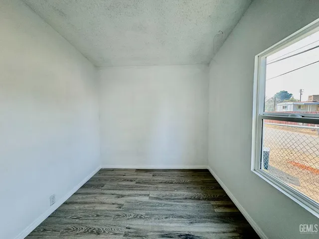 a view of a room with wooden floor and window