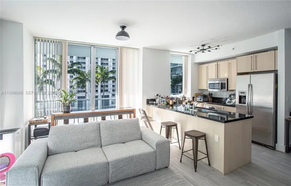 a kitchen with stainless steel appliances granite countertop a stove a refrigerator a sink and white cabinets