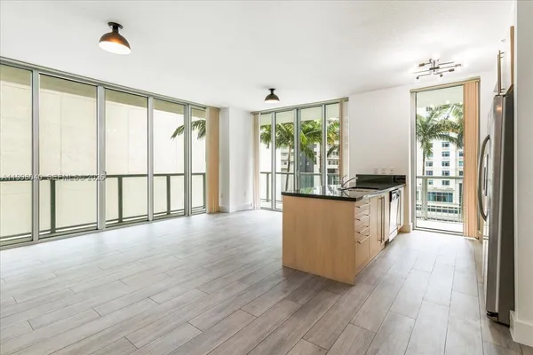 a view of a kitchen with kitchen island wooden floors and a large window