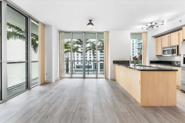 a view of a kitchen with wooden floor and a window