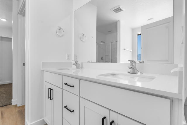 1355 West 2350 South, Unit 11 Perry, UT 84302 - Photo 32 of 39 Double vanity with white cabinetry and matte black hardware