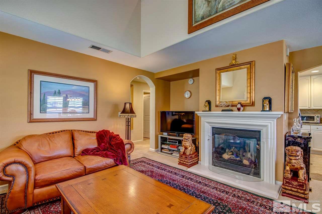 7675 Pebblestone Way Reno, NV 89523 - Photo 5 of 25 a living room with furniture a fireplace and a flat screen tv